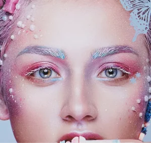 a close up of a woman's face with colorful makeup on it